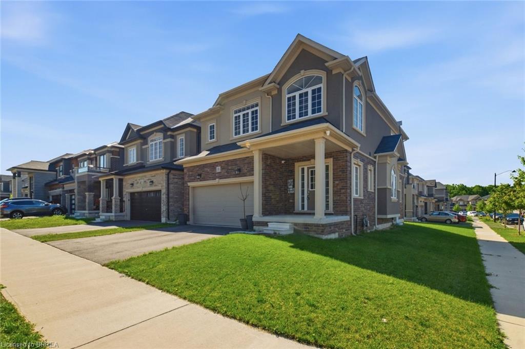 Stately residence featuring a covered front porch, a two-car garage, and a combination of stone and stucco exterior finishes