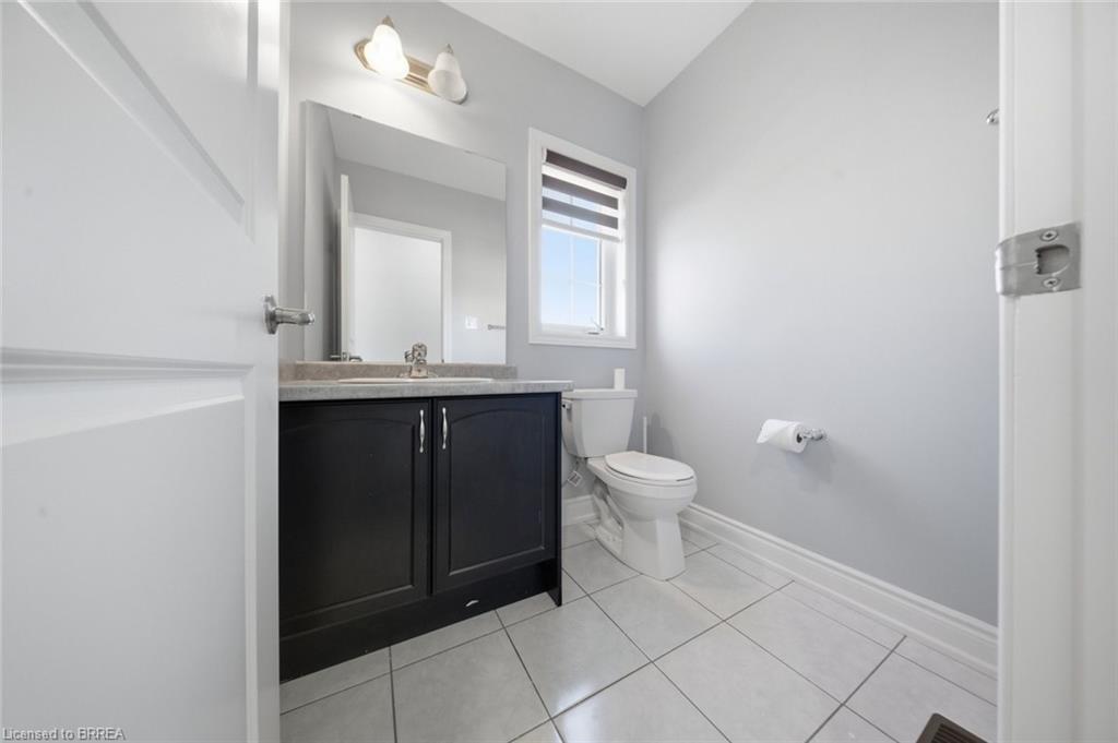 Bathroom featuring a dark wood-finish vanity with a light-colored countertop, a rectangular mirror, and a two-bulb vanity light fixture