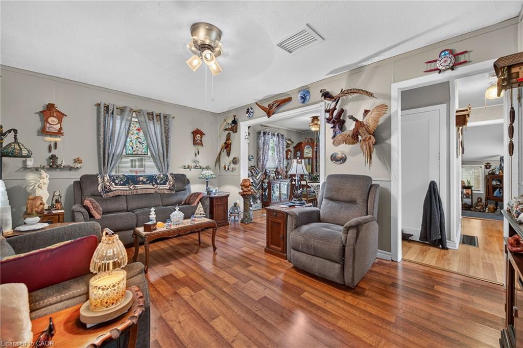 Spacious living area featuring wood-finish flooring, light gray wall paint, and white trim