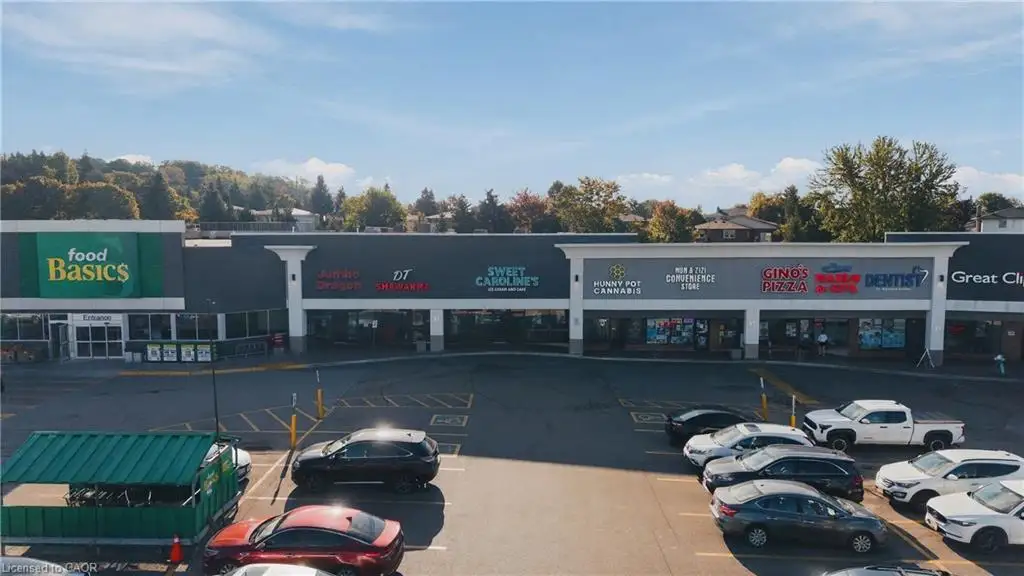 Commercial plaza featuring multiple retail storefronts, a prominent grocery store, and ample surface parking