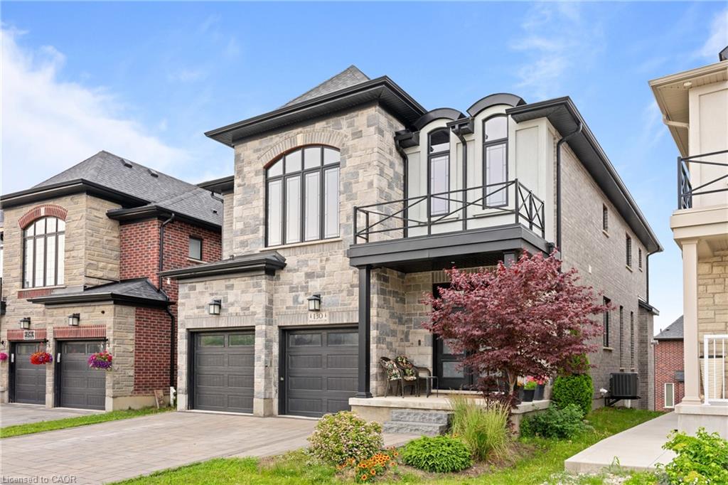 Contemporary stone and brick facade featuring a two-car garage with dark paneled doors