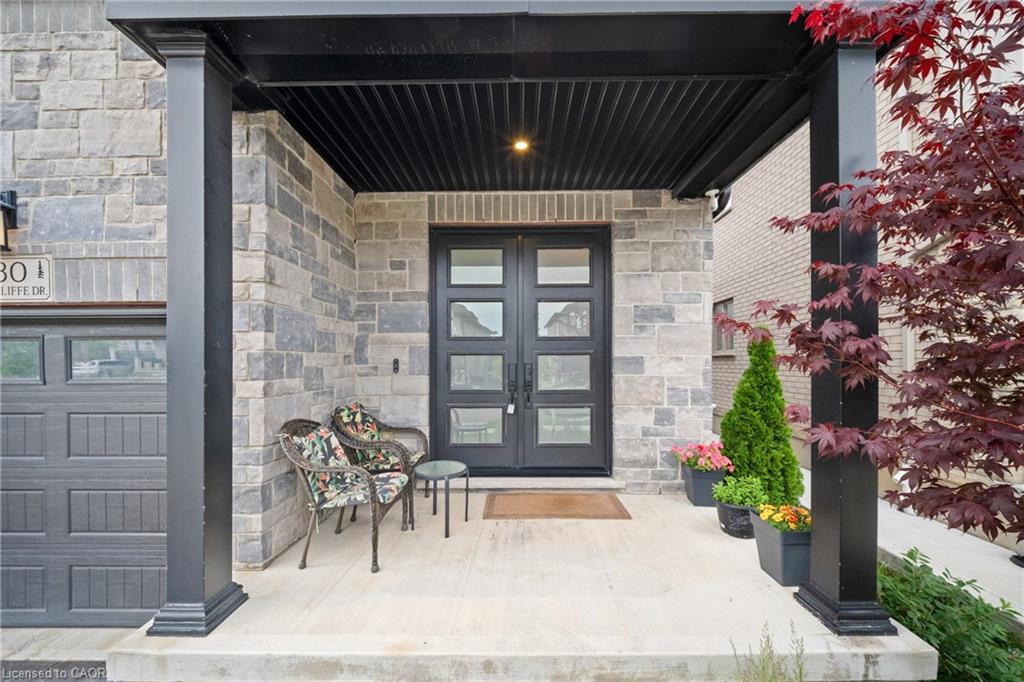 Stone facade with a covered porch featuring black support columns and a dark paneled ceiling