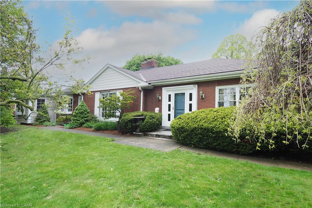 Brick exterior featuring white trim accents, a prominent front entry with sidelights, and a pitched roofline