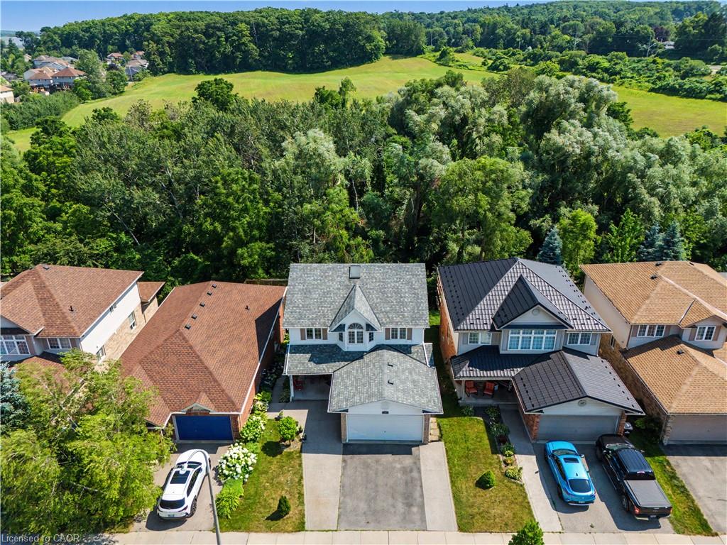 Two-story residence featuring a peaked roofline, a front-facing garage, and a paved driveway