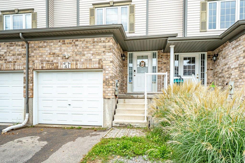 Brick and siding exterior featuring white garage door, front entry door with glass inserts, and concrete steps