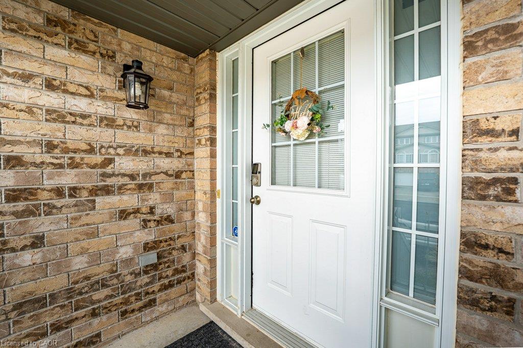 Brick exterior with a prominent entry door featuring a transom window, sidelight, and an exterior wall lantern