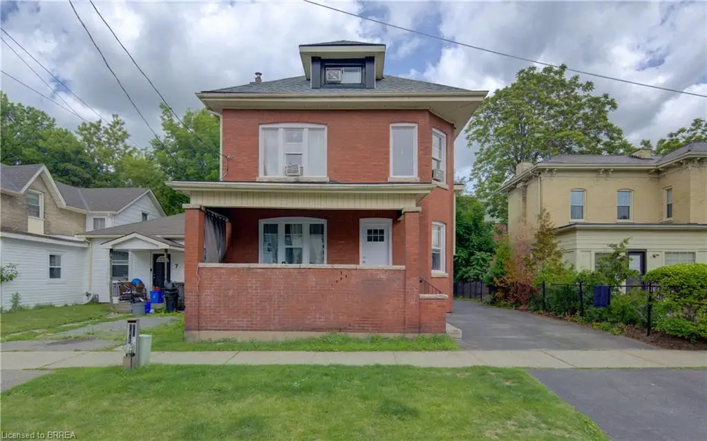 Brick exterior featuring a covered porch with a solid brick half-wall