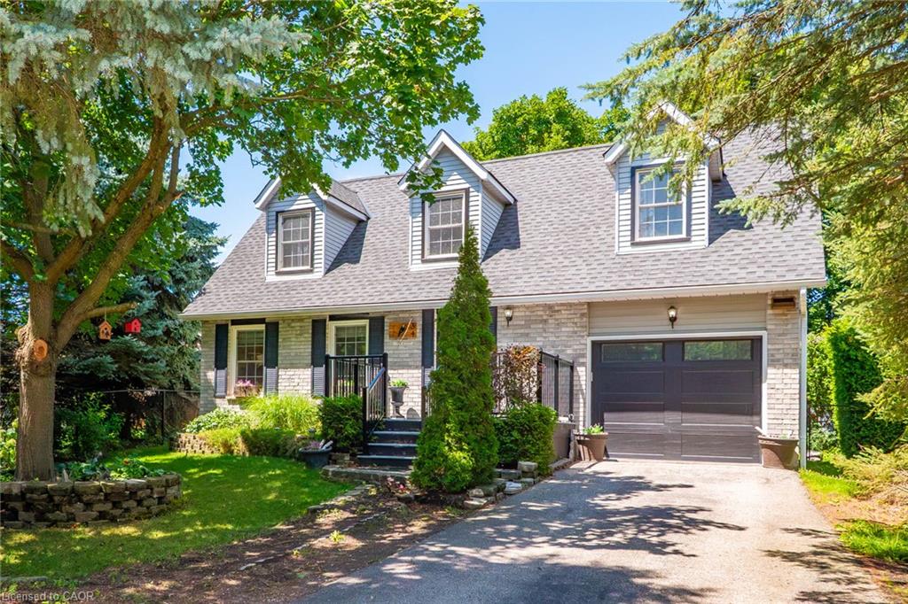 Exterior featuring a combination of light-colored stone and horizontal siding, a dark gray shingle roof, and three prominent dormer windows