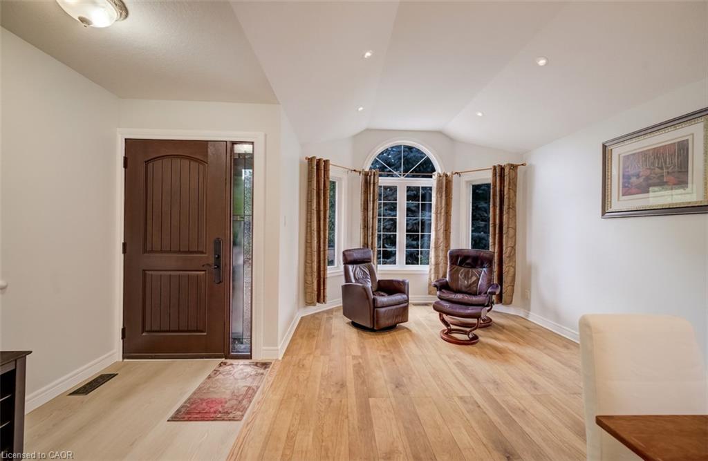 Wood-finish flooring throughout, vaulted ceiling, recessed lighting, and an arched window