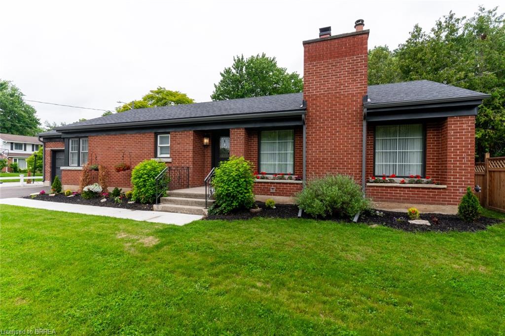 Brick exterior residence with a dark shingle roof and a prominent brick chimney