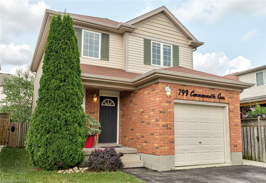 Two-story residence featuring a brick and siding exterior, an attached single-car garage, and a dark entry door with an arched transom