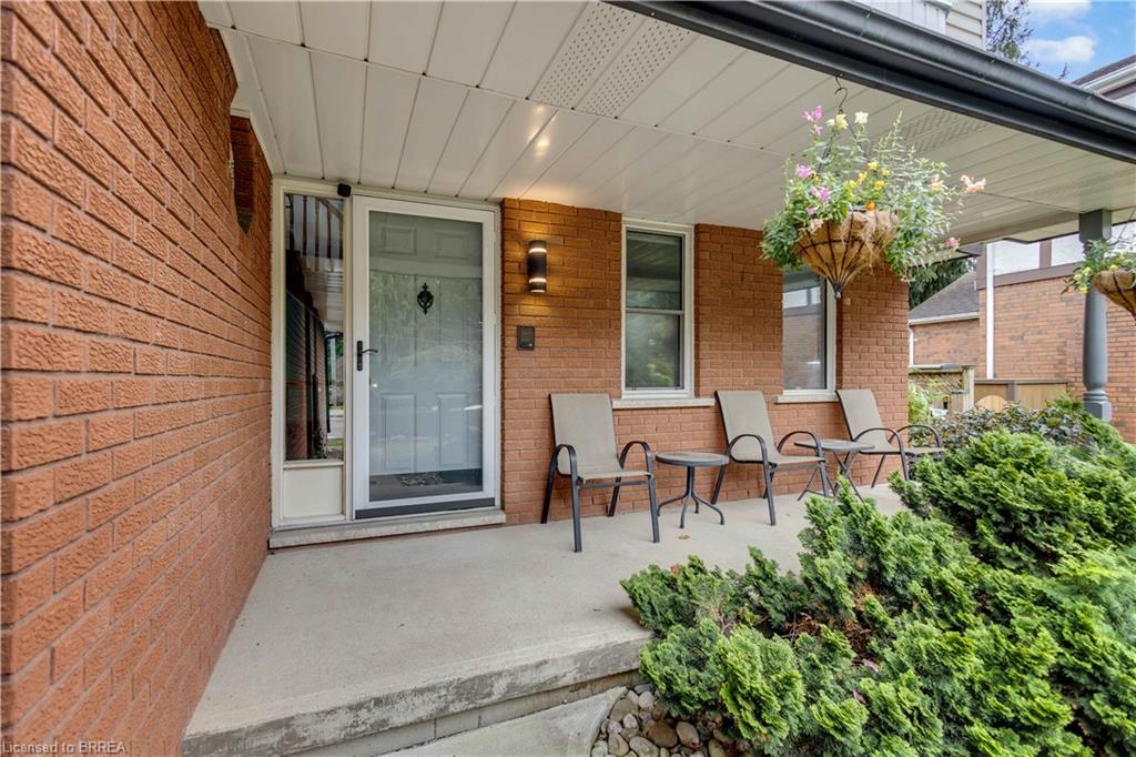 Brick exterior with a covered concrete porch, white soffit, and built-in lighting