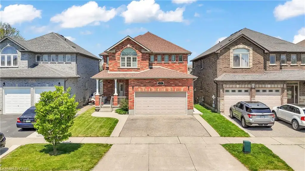 Two-story brick exterior featuring a covered porch, an arched window, and a single-car garage