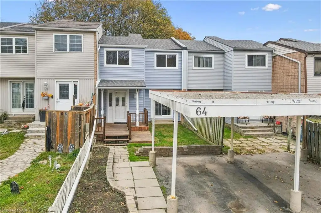 Multi-level townhouse exterior featuring vinyl siding, a private carport, and a wooden front deck