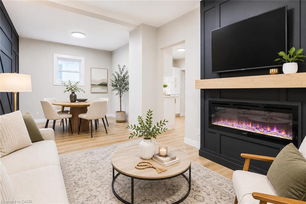 Built-in fireplace with a natural wood mantel, wood-finish flooring, recessed lighting, and a window for natural light