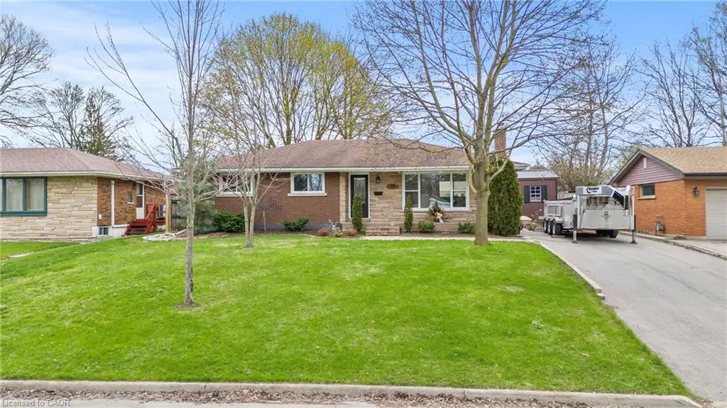 Single-story brick and stone veneer residence featuring a front lawn and paved driveway