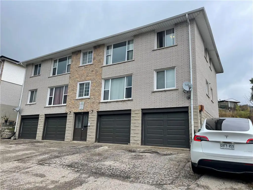 View of property featuring an attached garage and driveway