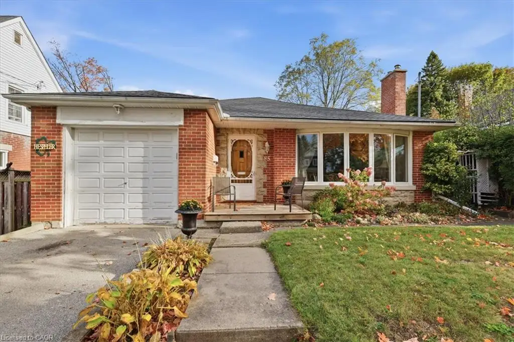 Single-story brick exterior featuring a multi-pane bay window, an integrated one-car garage, an exterior brick chimney, and a decorative front door with inset glazing