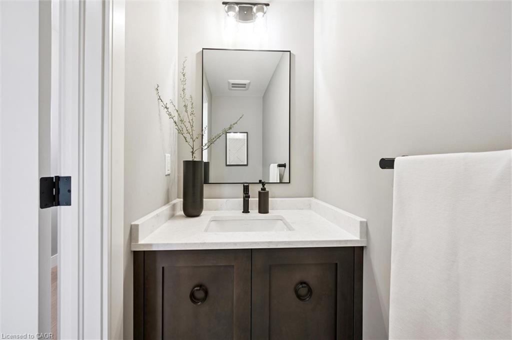 White vanity with a wood-finish cabinet, integrated sink, and matte black fixtures