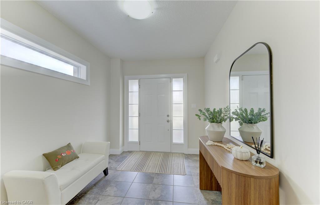 Entryway featuring a white door with frosted sidelights, a transom window, and tiled flooring