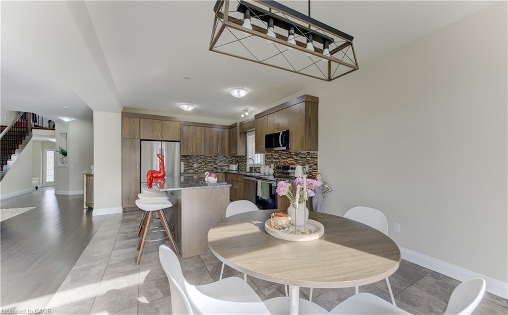 Open concept kitchen with wood-finish cabinetry, stainless steel appliances, and a tile backsplash