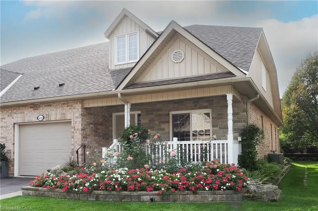 Brick and stone exterior with a covered porch, white railing, and decorative columns