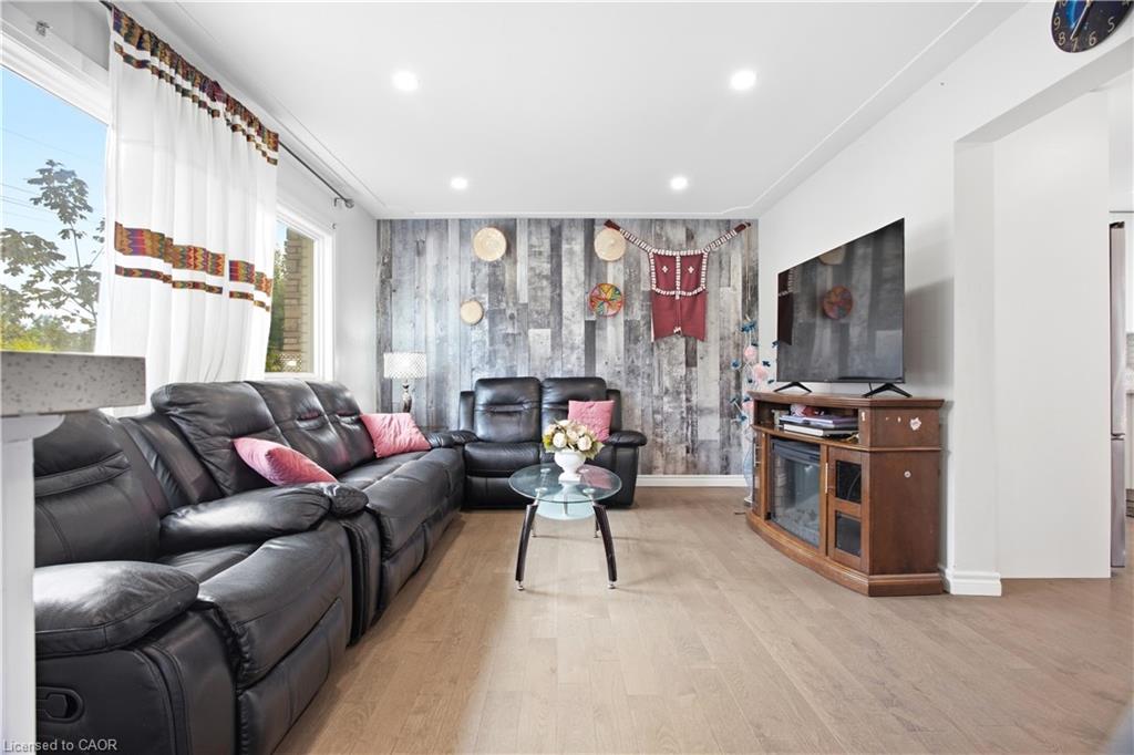 Recessed lighting, wood-finish flooring, and a feature wall with a distressed wood-look finish
