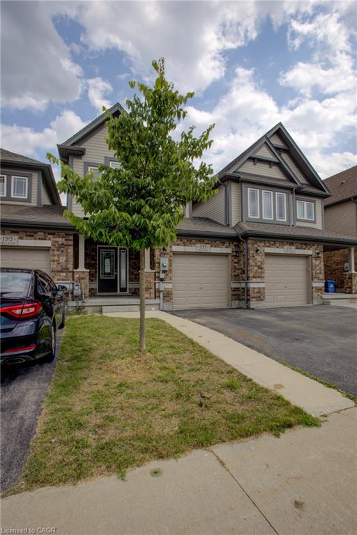 Two-story dwelling with a peaked roofline, multi-pane windows, brick and siding exterior, and an attached garage
