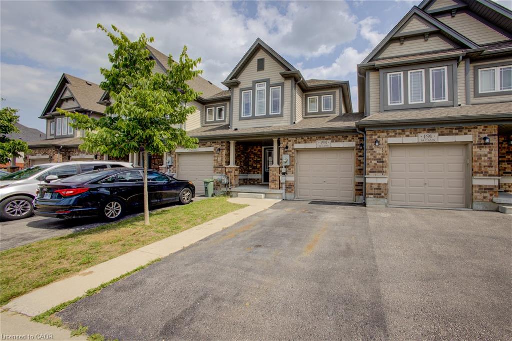 Brick and siding exterior with multiple gabled roofs, individual garage doors, and distinct entryways