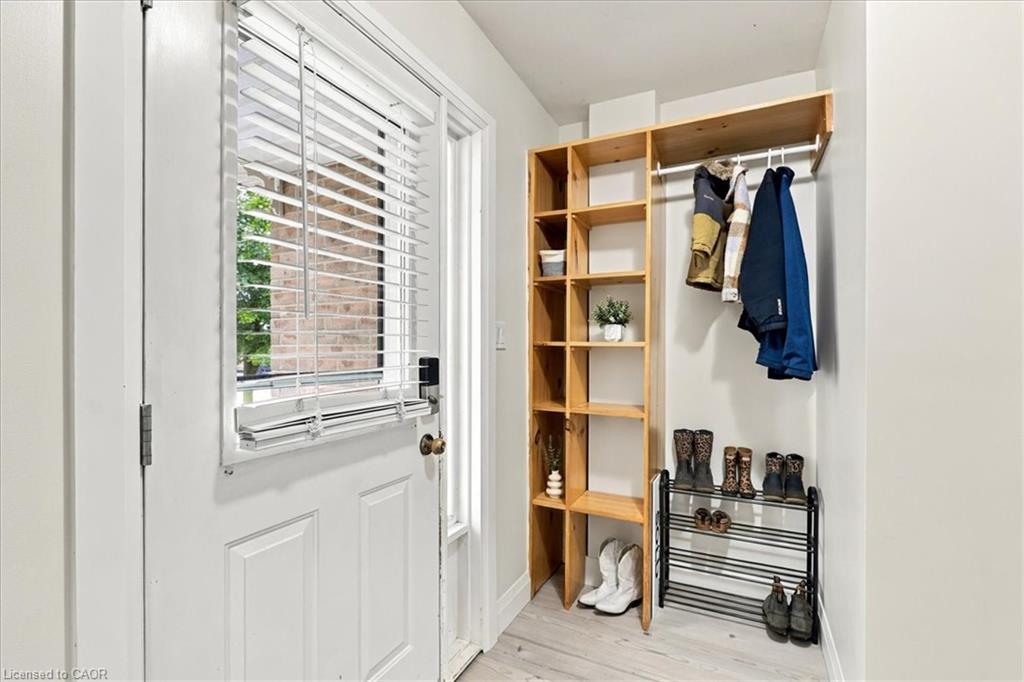 Entryway storage solution featuring light wood-finish shelving and a hanging rod