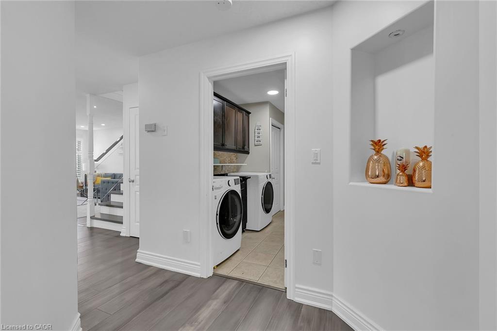 Dedicated laundry area with upper cabinetry and a tiled floor