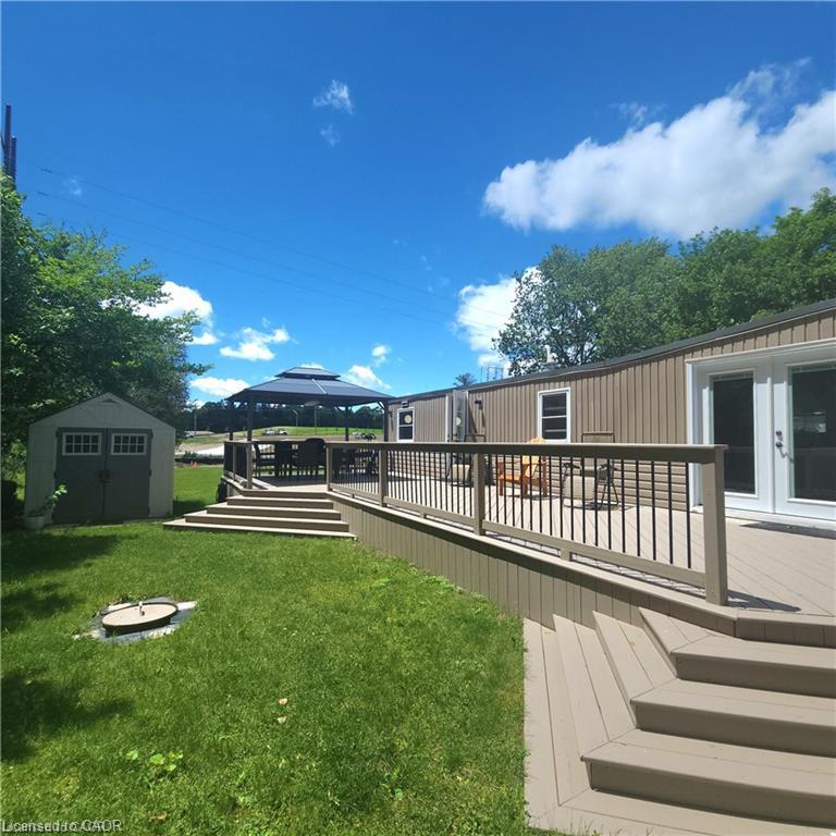 Expansive outdoor decking with multi-level design and composite material, featuring a dark gazebo and metal railings