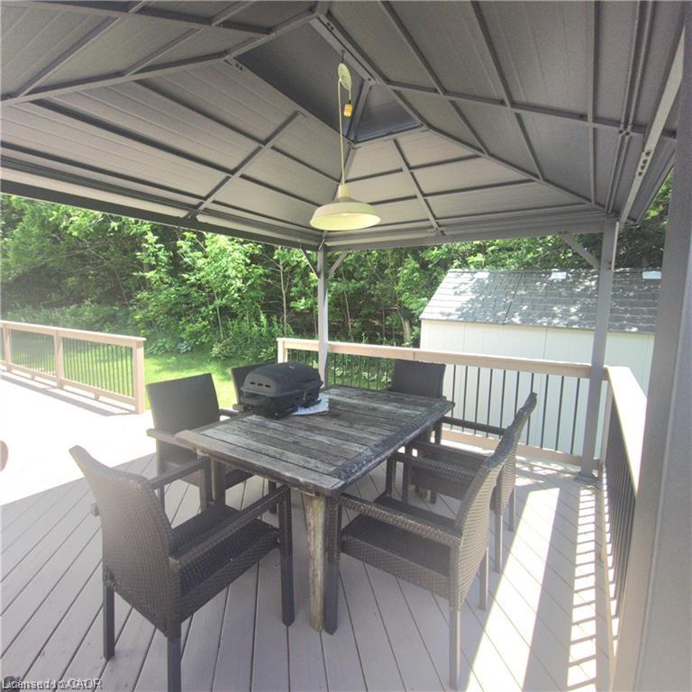 Expansive outdoor deck with composite decking, partial gazebo coverage, and a built-in overhead light fixture