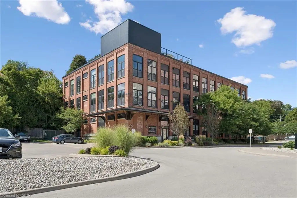 Brick facade building with multiple levels, featuring large windows and black window frames