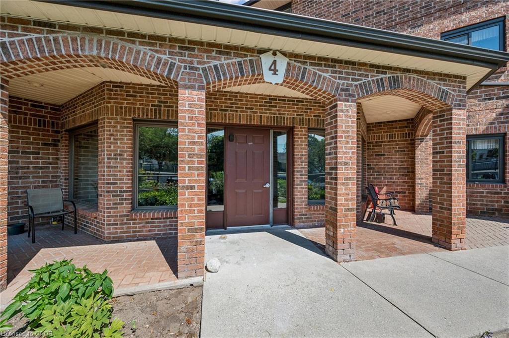 Brick exterior featuring arched entryways, a solid panel door, and multiple windows with dark frames