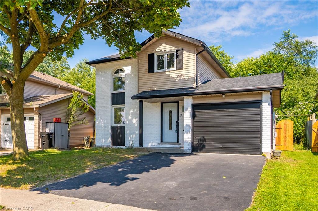 Two-story exterior with white brick and horizontal siding, featuring a black garage door and a covered entryway