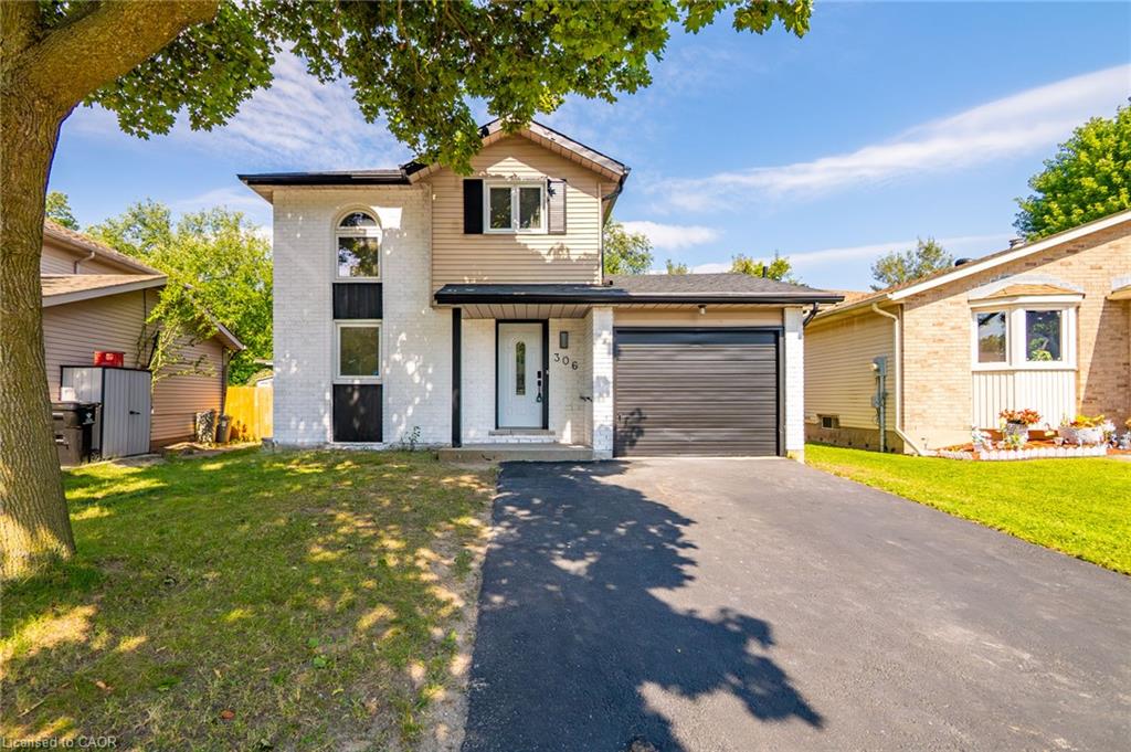 Two-story residence featuring a black garage door and an arched window on the facade