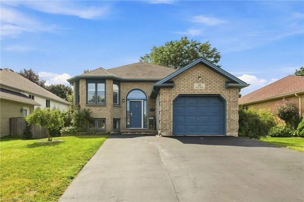 Brick exterior with a prominent arched entry, attached garage, and bay window