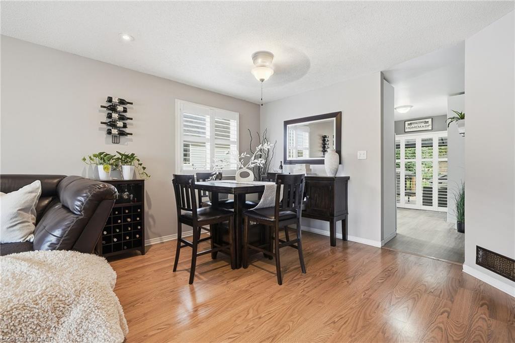 Hardwood-finish flooring, neutral wall paint, and white plantation shutters