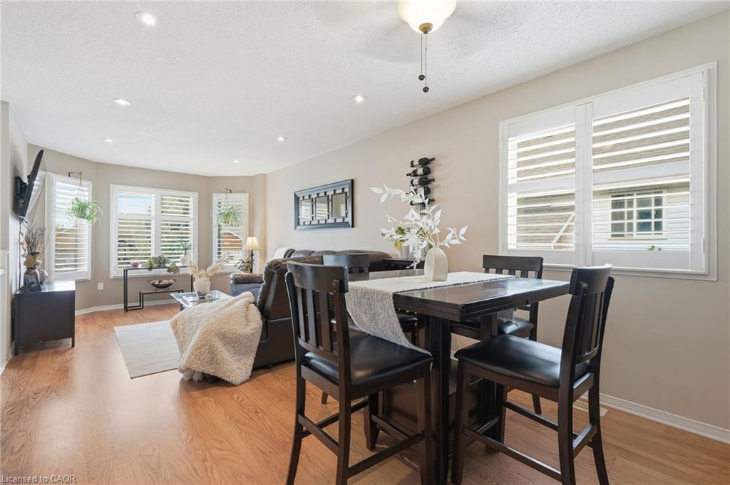 Recessed lighting, wood-finish flooring, bay window, plantation shutters, and a chandelier-style ceiling fixture