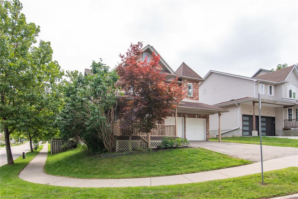 Brick and siding exterior with a peaked roofline, attached garage with white door, and a covered front entry