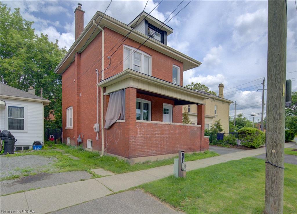 Brick exterior with a covered front porch featuring a brick half-wall