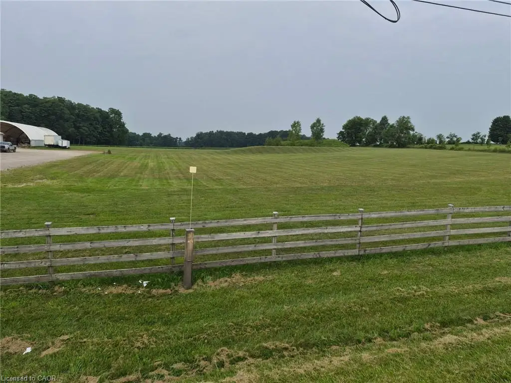 Expansive green field featuring a rustic wood fence