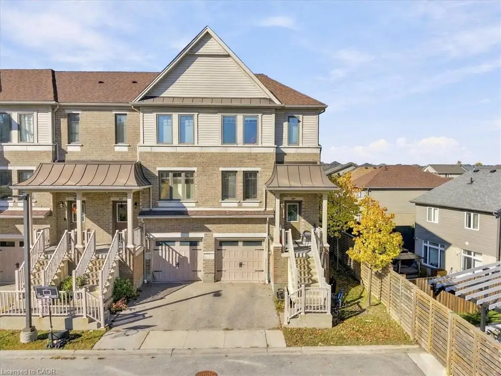 Multi-level brick exterior featuring a metal roof accent, built-in garages, and elevated entrance stairs with railings