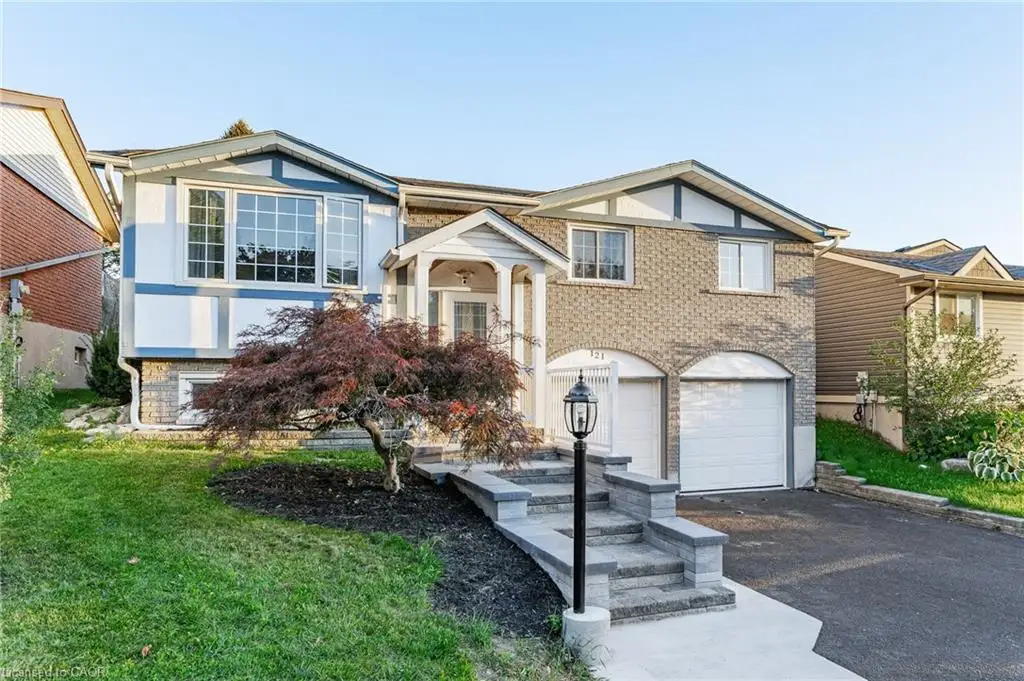 Two-story residence featuring a brick facade, integrated two-car garage with arched openings, and a prominent front entrance with a covered porch