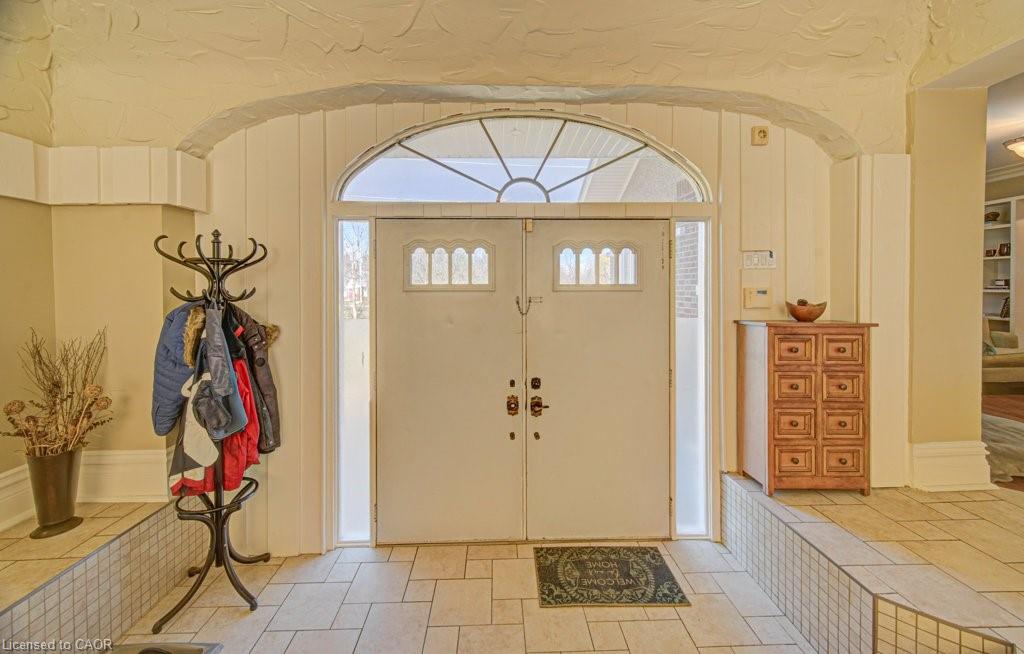 Double entry doors with transom window and sidelights, featuring decorative glass inserts