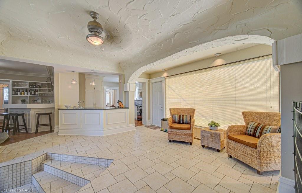 Spacious room featuring tile flooring, a multi-level floor plan, and an arched entryway
