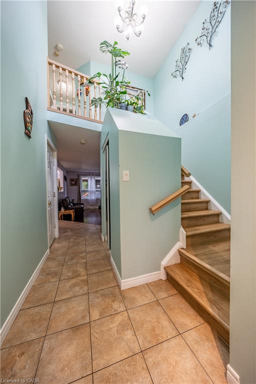 Two-story entry with tile flooring, wood-finish stairs, and an upper-level railing