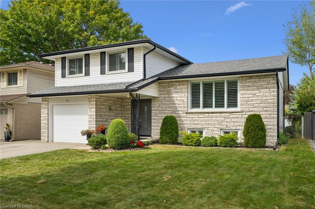 Split-level home featuring a stone and siding exterior, an attached single-car garage, and a covered front entry