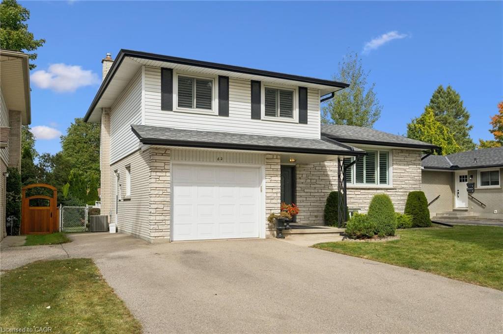 Two-story residence featuring light-colored brick and horizontal siding, an attached single-car garage, and a paved driveway